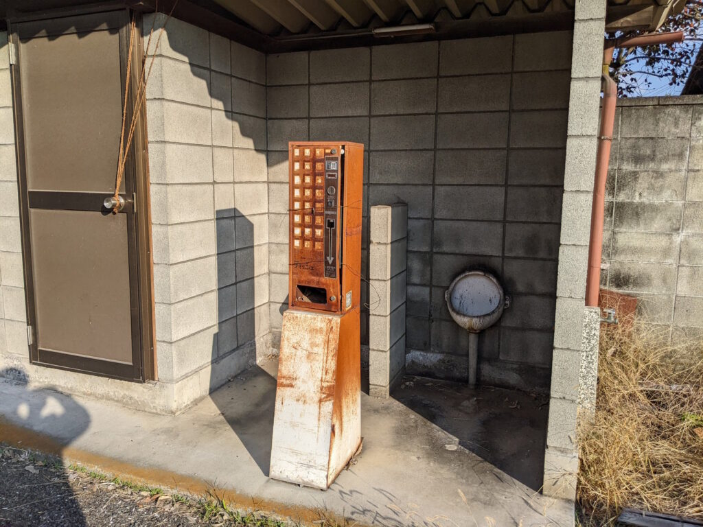 古いトイレと錆びたティッシュ自販機