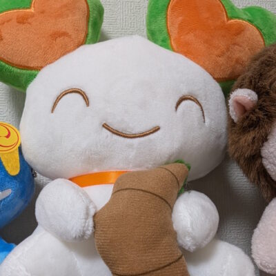 ララピーがミニクロワッサンを持っているお座りぬいぐるみ